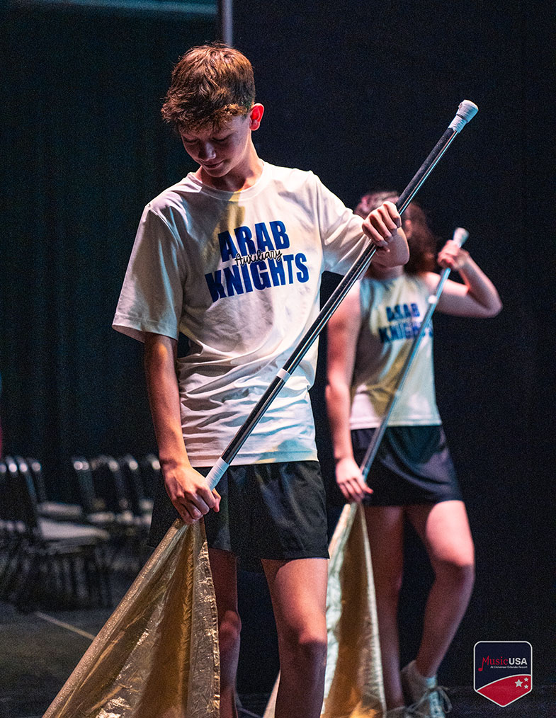 young performers on stage with their hands up