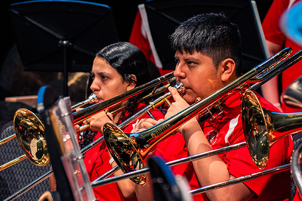 Young performers playing various horn instruments in a group